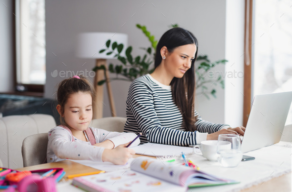 Mother with school girl indoors at home, distance learning and home office.