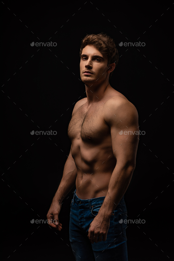 sexy man in jeans with bare muscular torso isolated on black - Stock Photo - Images