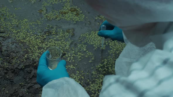Process of Taking Water Analysis From Swamp Using Flask and Pipette Wearing Protective Suit and alt