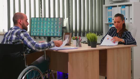 Businessman in Wheelchair Working in Corporate Office alt