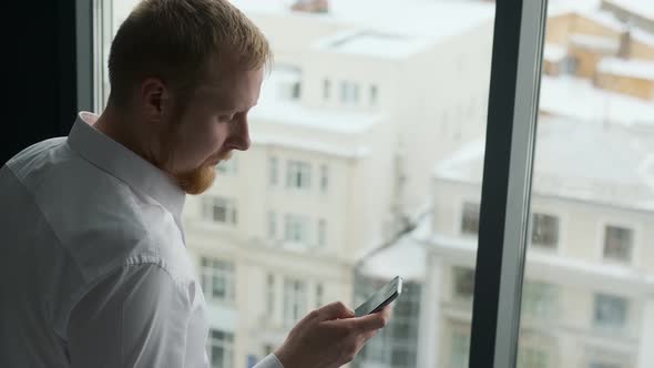 the man with the phone by the window