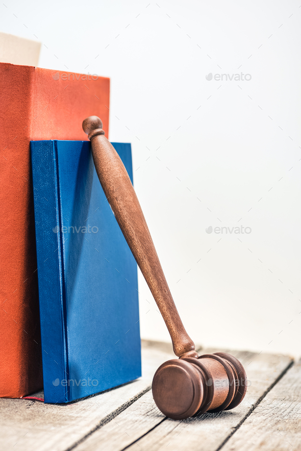 Close-up view of wooden mallet of judge and books on wooden table, law concept