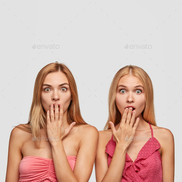 Two surprised women witnessed shocking and terrifying crime, cover mouthes with hands not to shout,
