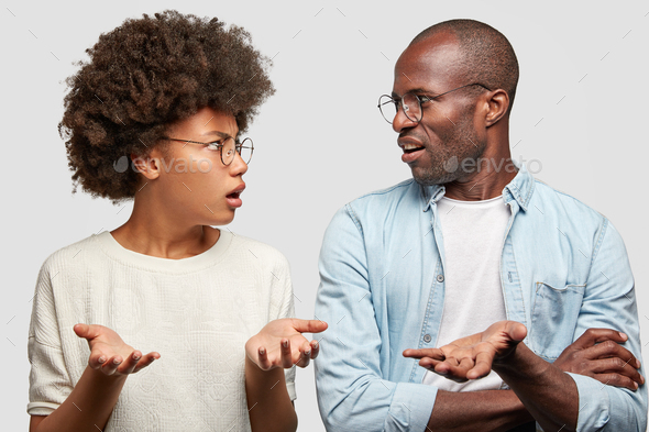 Confused African American couple look at each other angrily, clasp hands, don`t know where their mon
