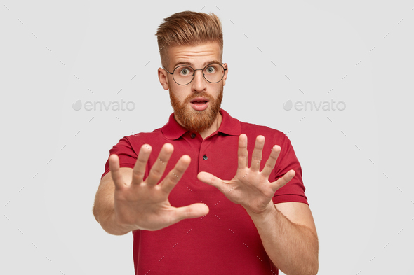 Stop, leave me alone. Intense unhappy man with foxy hair and beard, shows enough or stop gesture, ex