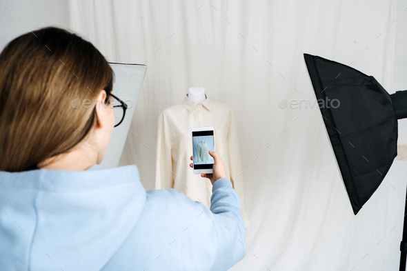AR VR Technology in Fashion Industry. Female designer shotting clothes on mannequin by cell phone - Stock Photo - Images