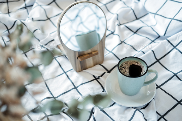 Morning cozy mood. Coffee in the bed. A cup of black coffee in bed on white checkered blanket - Stock Photo - Images