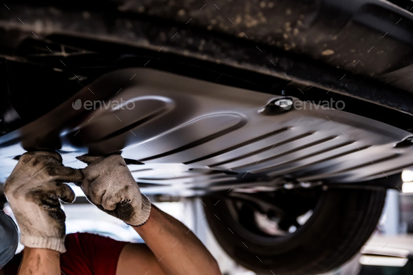 Car mechanic checks engine protection on Service station - Stock Photo - Images