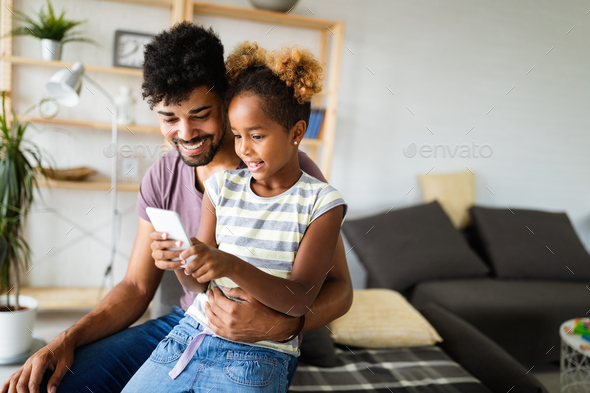 Happy family, technology concept. Father spending time with his daughter, using mobile phone