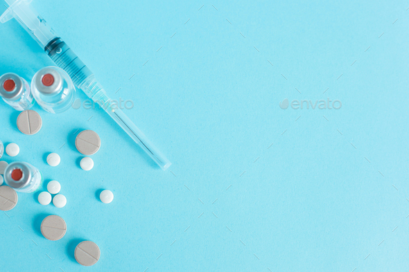 Drugs and Syringe on blue background with copy space Stock Photo by  Garakta-Studio