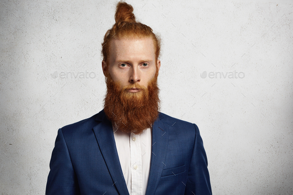 Styled and bearded hipster person with cuban cigar in gray