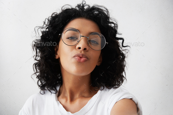 brunette serious lady keeps hand on rim of spectacles, concentrated at  computer screen Stock Photo by StudioVK