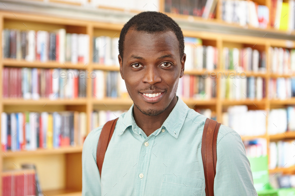 People, knowledge and education concept. Attractive young Afro American male with knapsack came to b - Stock Photo - Images