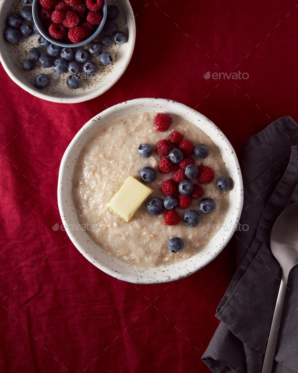 Oatmeal porridge with blueberry, bilberry. Breakfast in white bowl with fresh berries, vertical - Stock Photo - Images