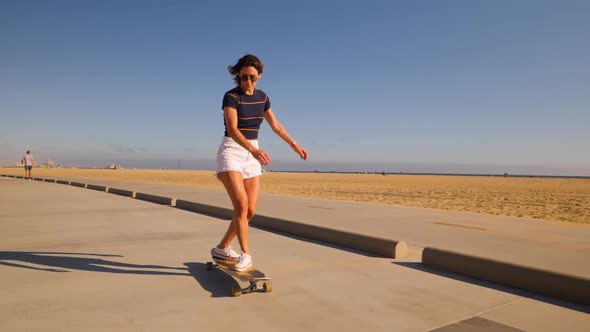Casual Woman Longboarding On Desert Background Riding Skateboard. Wide, Slow Motion alt