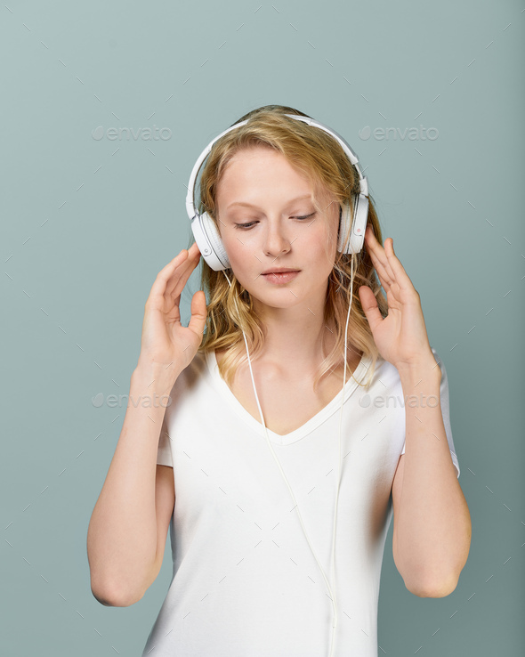 Placeit. Closeup portrait of young woman closed eyes listening music via headphones on color neutral - Stock Photo - Images