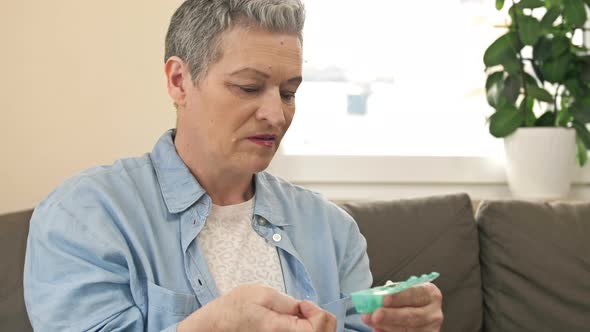 Mature Woman Laying Out Her Pills in a Small Weekly Pillbox alt