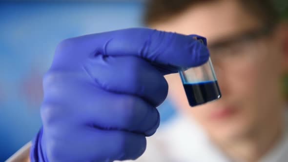 Scientist Holding Blue Tests
