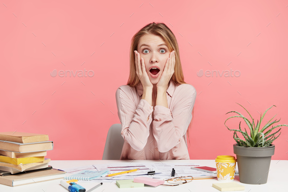 Shocked female copywriter realizes her bad mistake in writing article, can`t improve it, looks with
