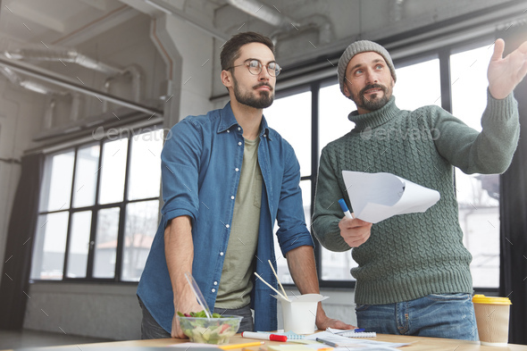 People, business, cooperation and working lunch concept. Two talented men meet together, discuss mai - Stock Photo - Images