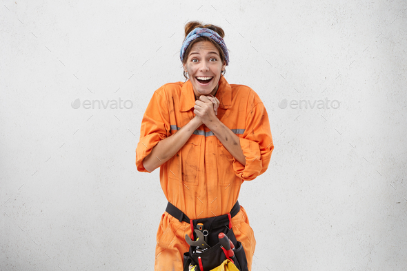 Occupation, job and profession concept. Attractive young woman electrician or plumber with big aston