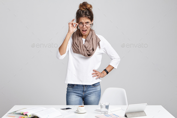 Strict female boss, looks angrily through glasses, going to shout at inferiors who don`t want to wor