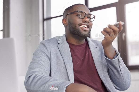 Attractive black male enterpreneur makes voice call for consulting about cash remittance, uses moder
