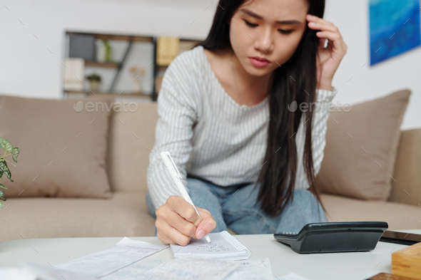 Woman counting sum of monthly expenses