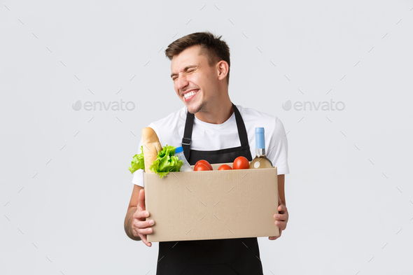 Retail, grocery shopping and delivery concept. Silly cheerful salesman in store packing order for