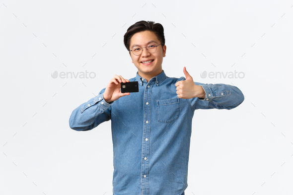 Satisfied young asian male entrepreneur, starting own startup, open bank account, showing thumbs-up