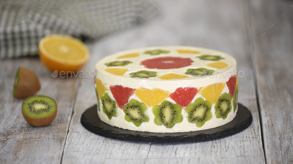 Delicious fruit mousse cake. Cake decorated with fresh fruits in jelly.