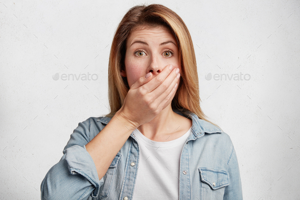 Oops! Pretty young female model tries not tell secret to her friends, covers mouth while gossiping,