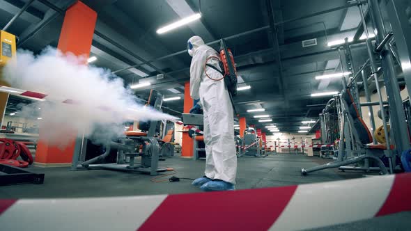 Sanitary Inspector Is Fumigating Fitness Machines in the Gym alt
