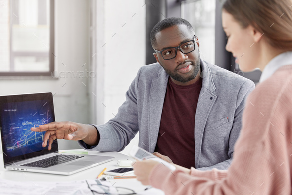 Serious black African American male tries to explain his female trainee startegy of development sale - Stock Photo - Images