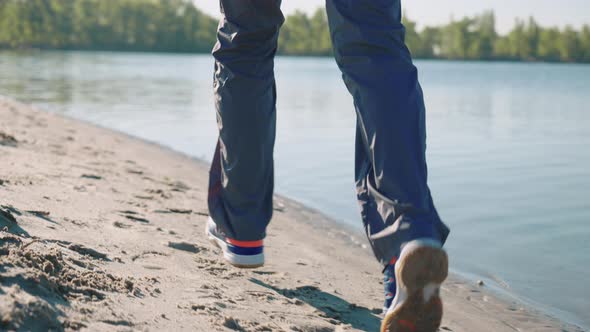 Slow Motion Feet of Jogger Running on Beach alt