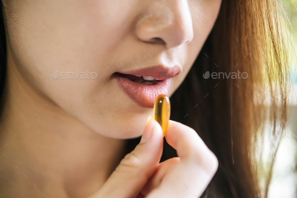 Young woman taking medicine pill after doctor order
