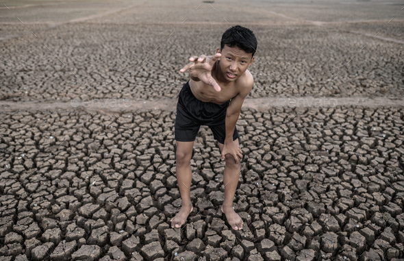 The boy stood bent on his knees and made a mark to ask for rain, global warming and water crisis. - Stock Photo - Images
