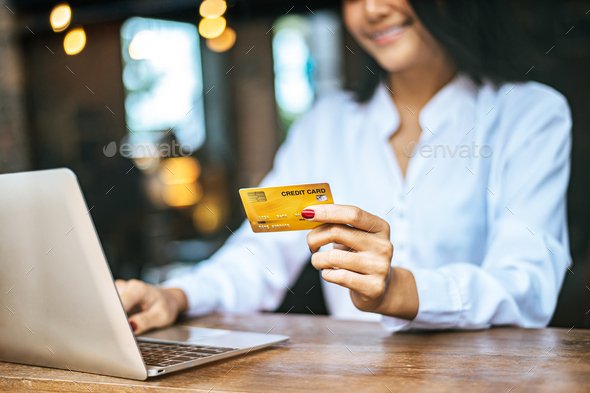 woman sat with a laptop and paid with a credit card in a coffee shop. - Stock Photo - Images