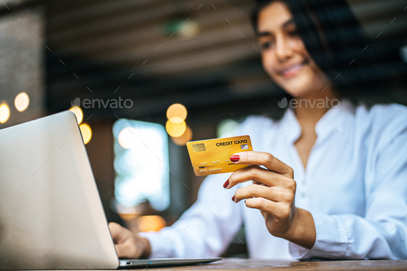 woman sat with a laptop and paid with a credit card in a coffee shop. - Stock Photo - Images