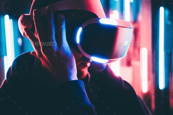 Portrait man touching and trying modern VR headset on his head,