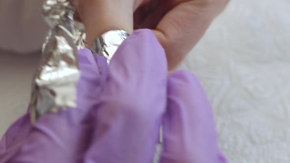 A Young Woman Does a Manicure. Wraps His Fingers in Foil To Remove the Old Gel. Nails Manicure
