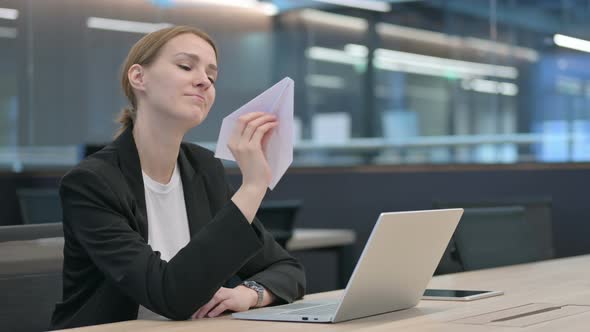 Businesswoman with Laptop Holding Paper Plane alt