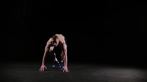 A Young Sports Man Doing a Backflip and Doing a Push Up  Endirance Training in Black Studio alt