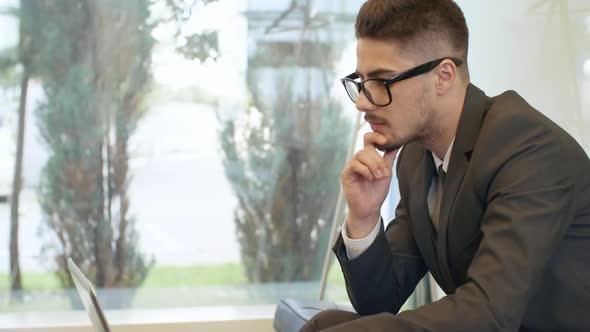Businessman Using Laptop when Working on Project alt