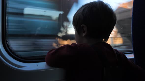 Boy looking through the window in the train. Traveling with children. Boy at train.