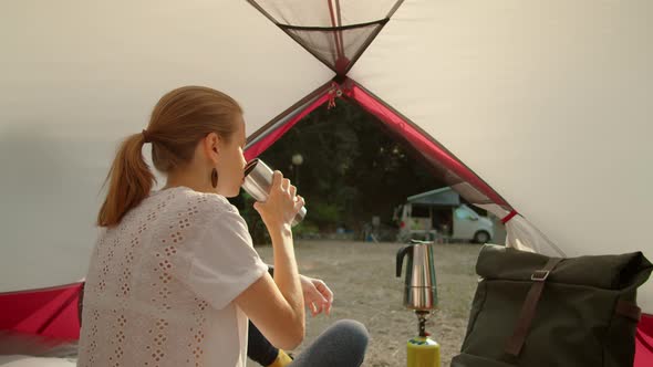 Outdoor Girl Enjoys Hot Coffee in Camping Tent in Morning