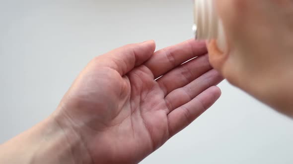 Pills Capsules Drugs Pouring From Bottle in Doctor's Hand alt