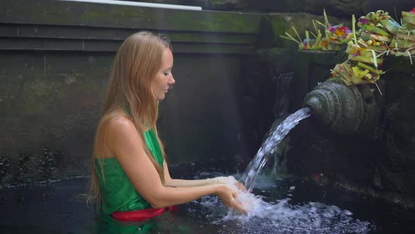 Slowmotion Shot of a Young Woman Visiting the Holly Springs in Indonesia. Tirta Empul Holy Water alt