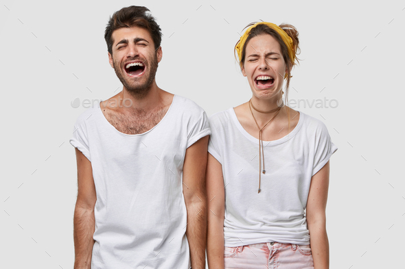 Depressed family couple cry desperately, feel negative emotions, wear white casual t shirt, frown fa