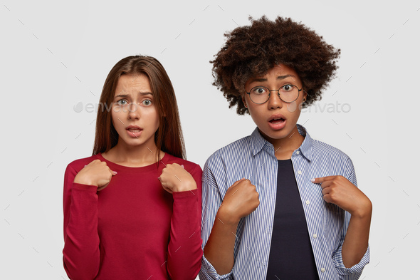 Photo of desperate indignant two women point at each other with indignant expressions, recieve unexp - Stock Photo - Images